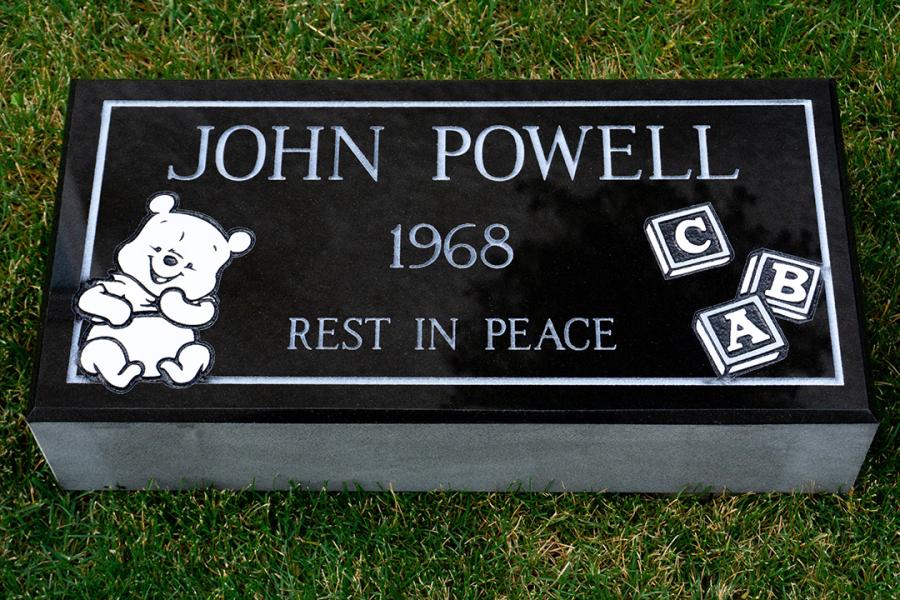This 20 x 10 x 4 Midnight Black Flat Grass Memorial features a sandblasted Winnie the Pooh and baby block design.