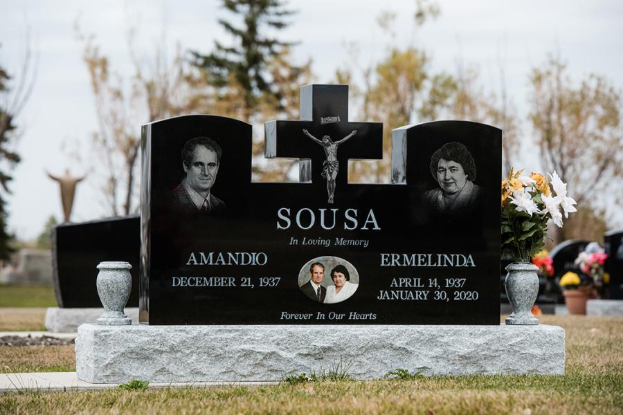 Sousa, Midnight Black custom design  double memorial on a Galaxy Grey base and two matching grey vases. This memorial features impacted etched portraits, Jesus and a stainless steel coloured portrait picture located in Assumption cemetery