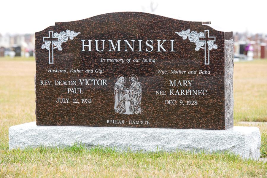 Humniski, a traditional style notched top memorial in Cats Eye Brown on a standard Galaxy Grey base. Customizations to this traditional style memorial are all sides polished with one Diamond Impact Etched religious motif.