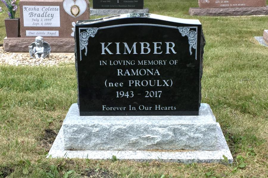 Kimber, a traditional size monument that can be used for two individuals or just one as shown here. Shown here, a Midnight black memorial on a grey base and a granite foundation installed by our company. 