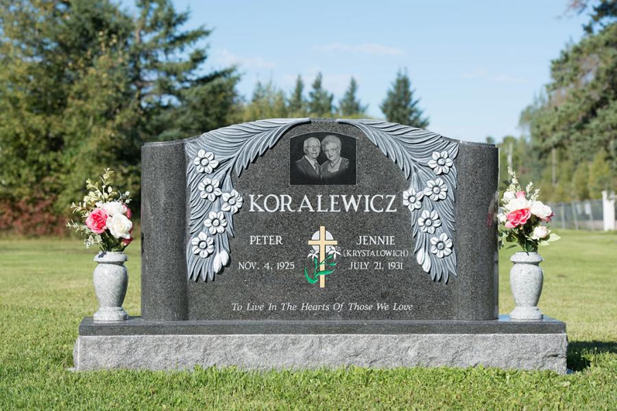 Koralewicz, Custom Design Pillar style Britts Blue Granite Memorial. Featured add-ons, custom matching 2" polished top base, Diamond Impact Etched portrait and two granite vases.