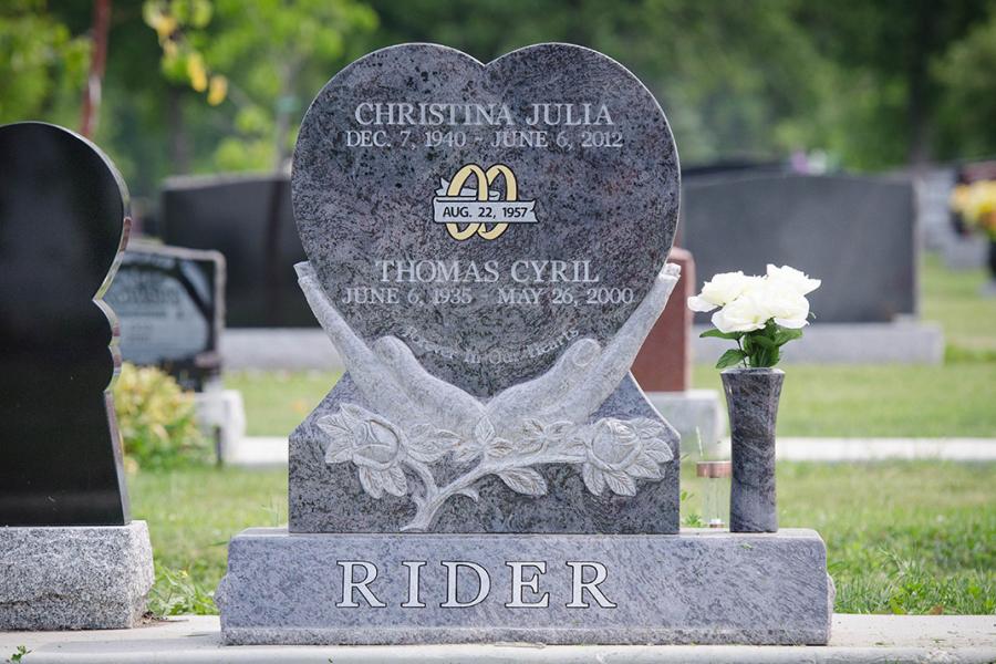 Bahama Blue Custom Design Granite Heart Memorial installed in Brookside cemetery with sculptured hands on a custom matching polished face slant base