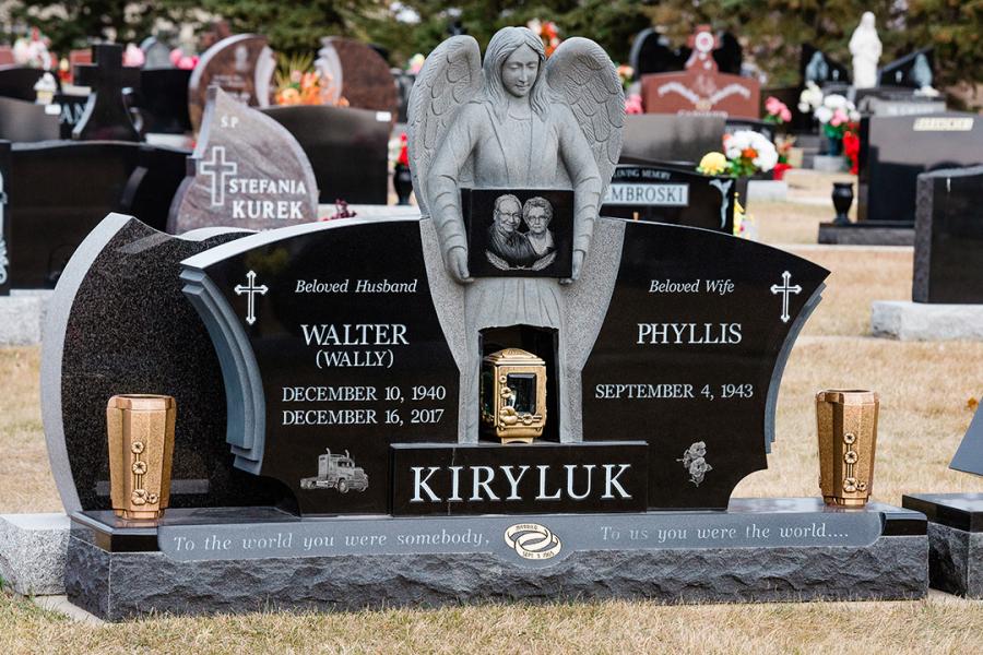 Krilyuk, Custom Design Wing-style Midnight Black memorial with sculptured angel. Featured add-ons, Bronze flower vases, gold paint detailing, one bronze lantern, and one Diamond Impact Etched portrait on a custom matching base