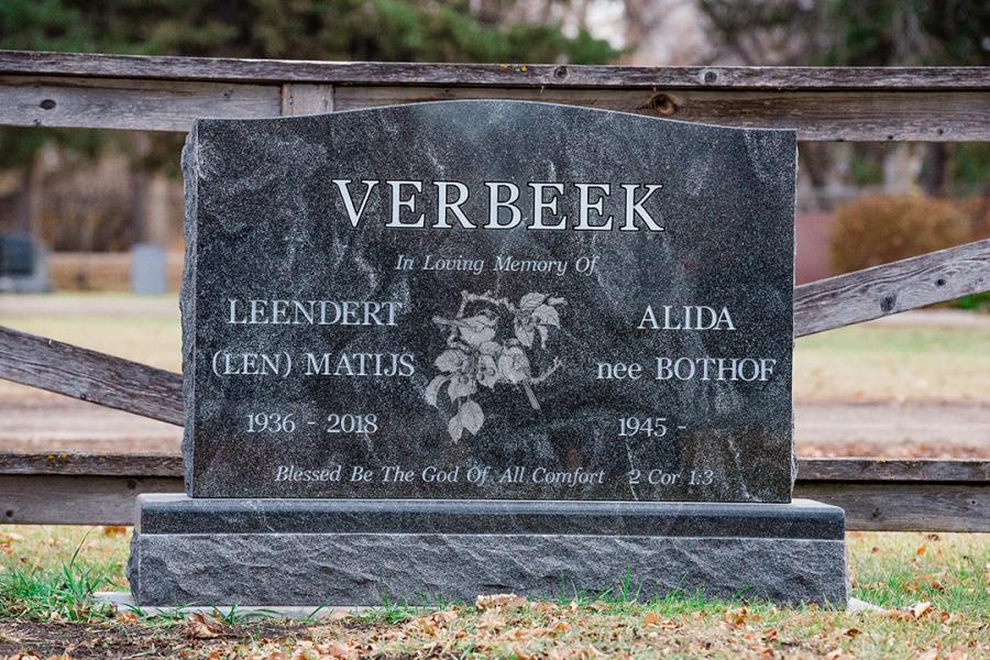 Verbeek, a traditional style Jet Mist granite memorial. Customizations to this traditional style memorials is a matching polished top  2" margin base and one Diamond Impact etched floral design.