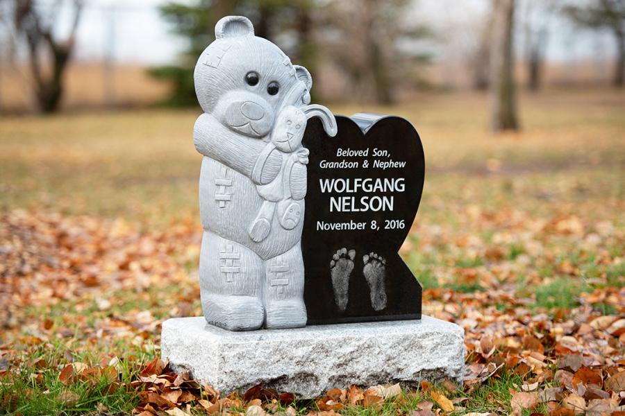 This custom design sculptured teddy and Midnight Black granite heart memorial on a Galaxy Grey base can be found in the infant section of Brookside cemetery. It features a Diamond impact etching of this sweet angels footprints. 