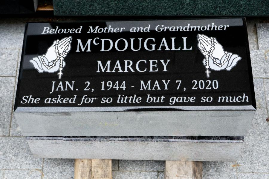 McDougall, a 20 x 10 x 4 Midnight Black Flat grass marker, with two sandblasted praying hands and rosary. Due to the high contrast in natural rock and polished finish, Midnight Black memorials turn out crisp and the letters are left without paint for a maintenance free option. 